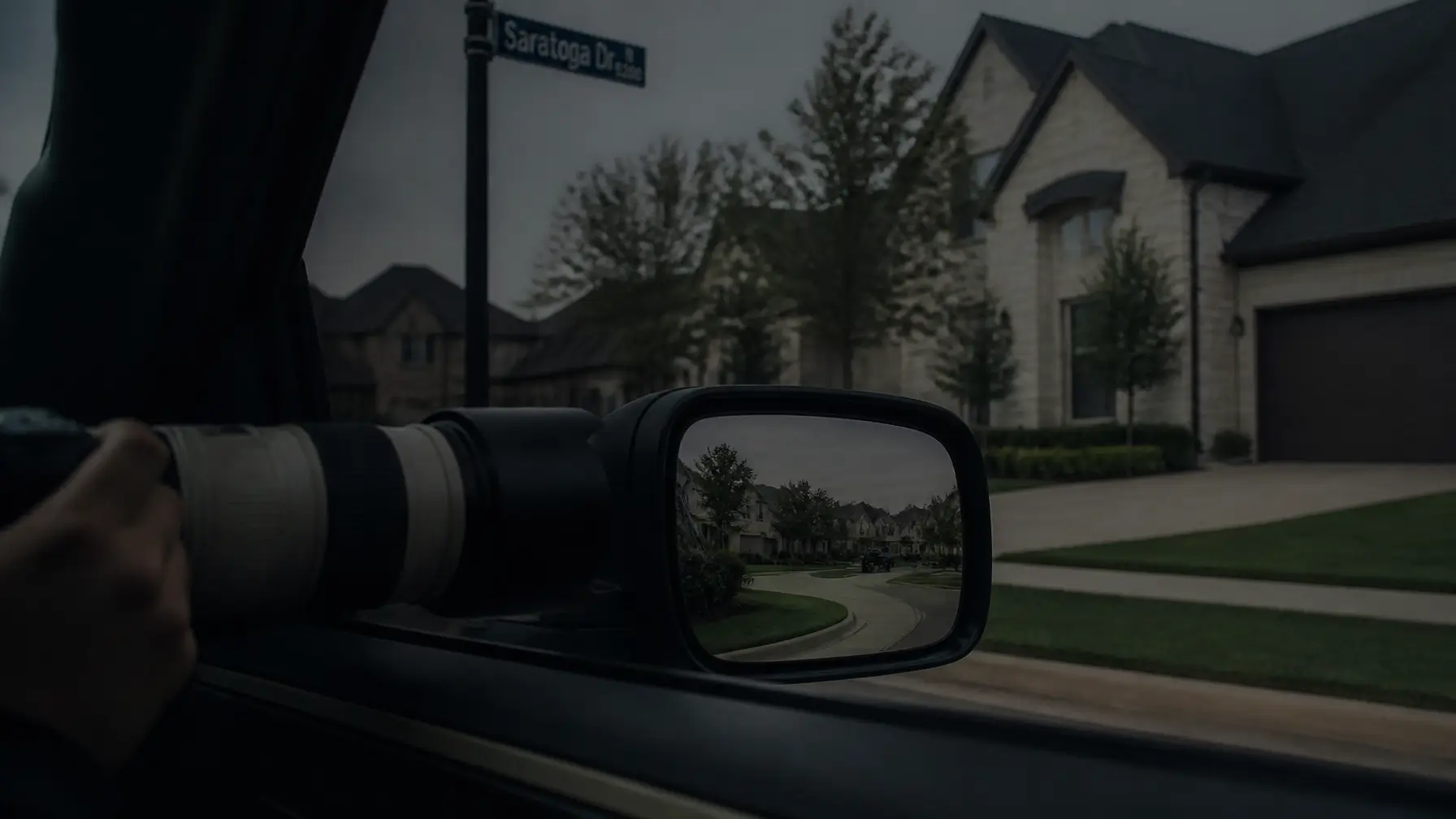 A discreet surveillance camera with a long lens visible from inside a vehicle, looking out at a residential street in a Dallas suburb.