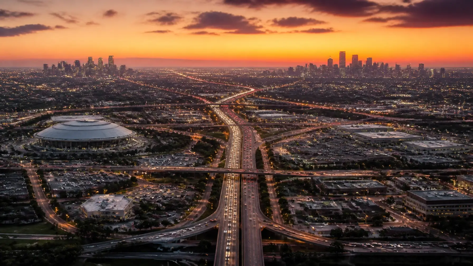 An expansive aerial view of the Dallas and Fort Worth skylines at sunset, representing the wide service area of Armstrong Investigations across the DFW Metroplex.